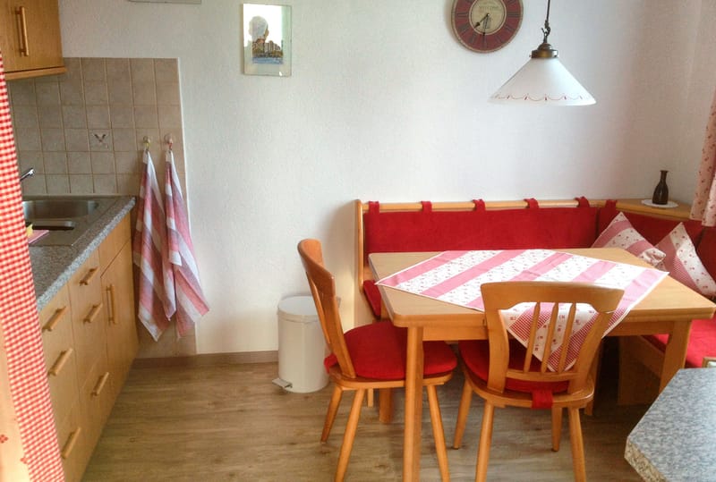 Essecke mit Eckbank, roten Polstern und gedecktem Tisch