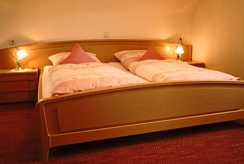 Schlafzimmer mit Doppelbett und rosa Bettwäsche