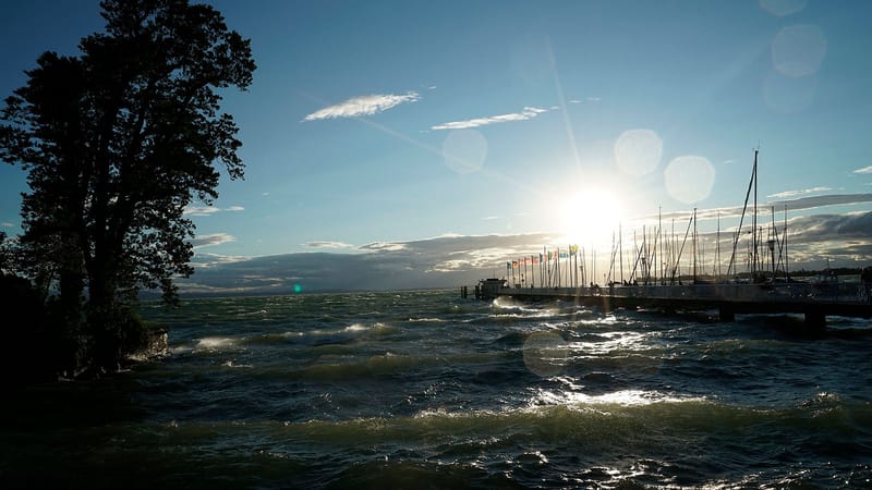Gegenlicht über dem Bodensee mit Steg und Segelbooten