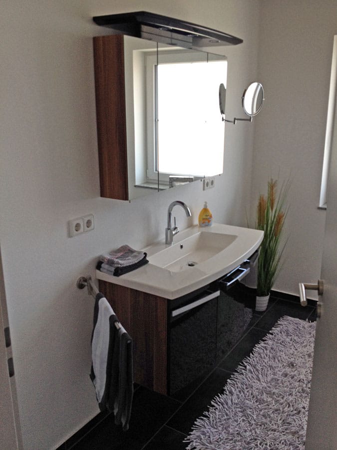 Badezimmer mit Waschtisch und Spiegelschrank (Hochformat)