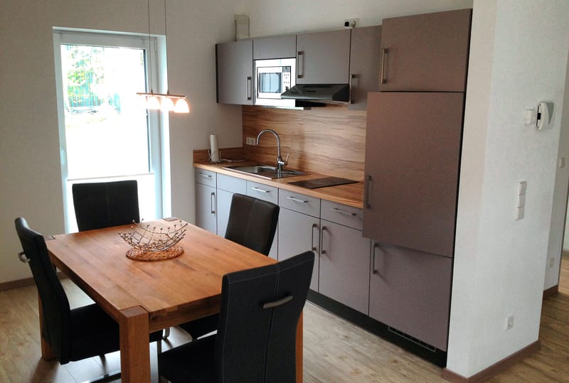 Küchenzeile mit Holztisch und vier dunklen Stühlen